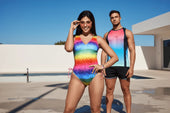 Rainbow-colored geometric patterned one-piece swimsuit with pink tie-side strings for pride and rave wear confidence.