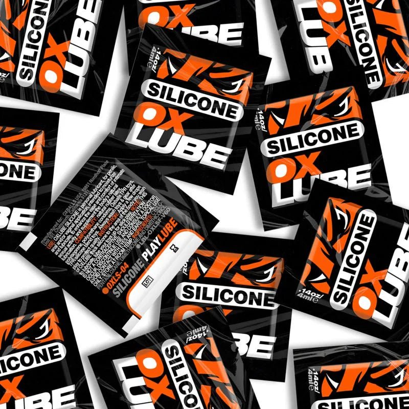 Black and orange silicone lubricant sachets with bold white text branding in a lubricant sachets collection