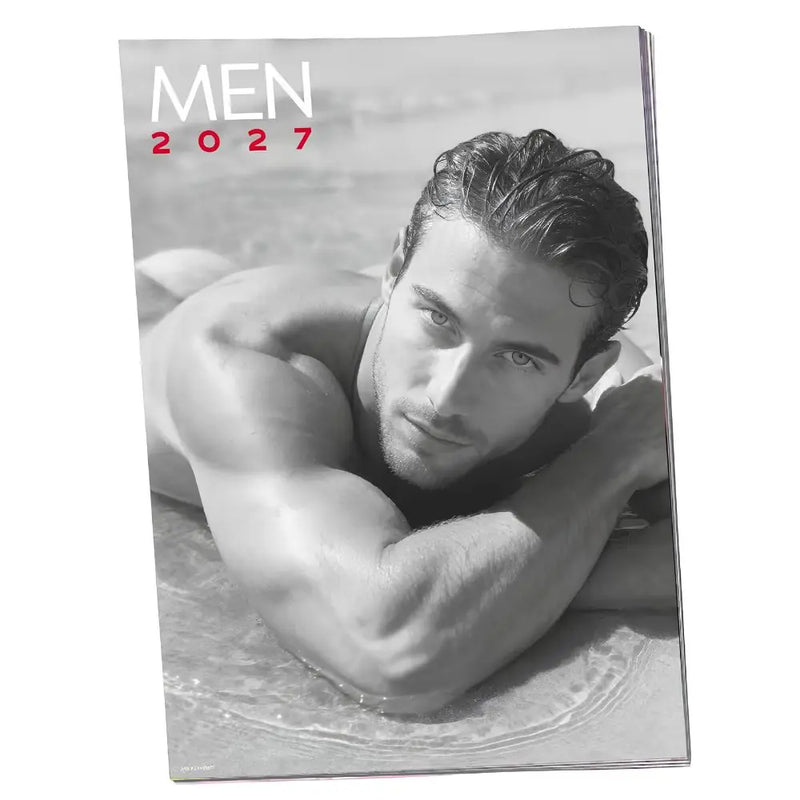 A shirtless man lying prone on shallow water surface, looking sideways.