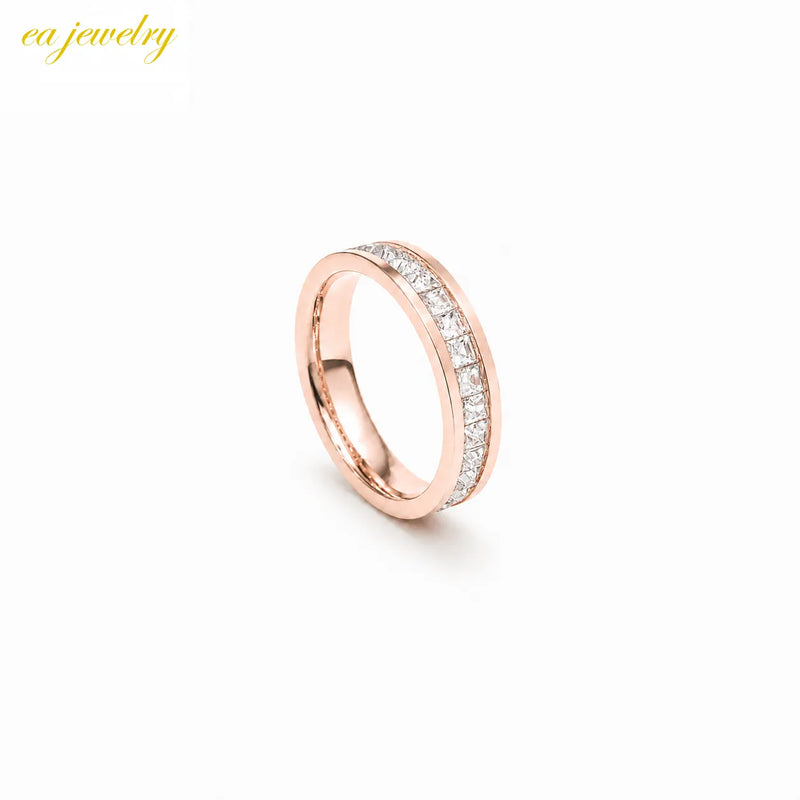 A rose gold band ring features channel-set small square stones inside.