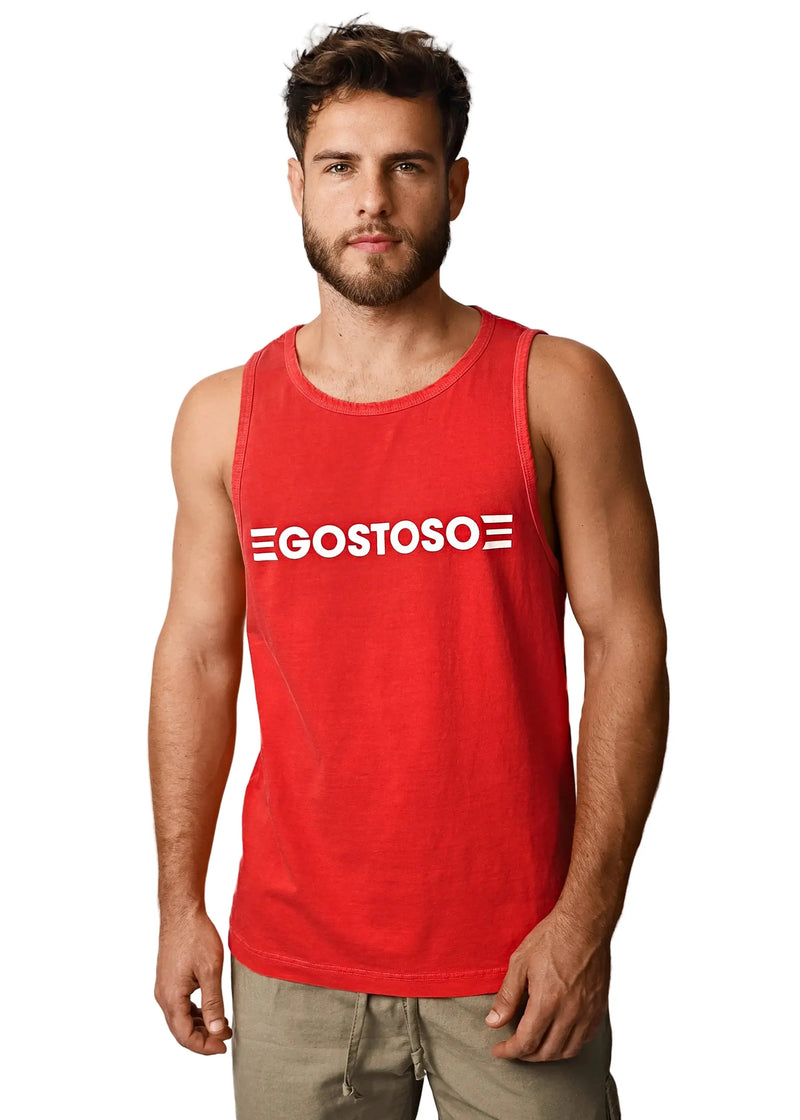 A bearded man wears a red cotton tank top against white.
