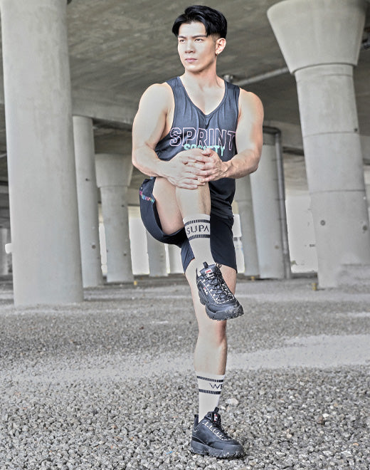 Black athletic shoe with thick soles and laces in a men’s socks collection front view