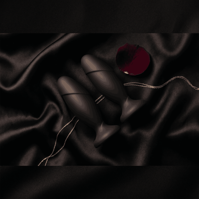 Anal Adventures black silicone anal plugs on black satin with rose petal, dark luxury editorial flat lay