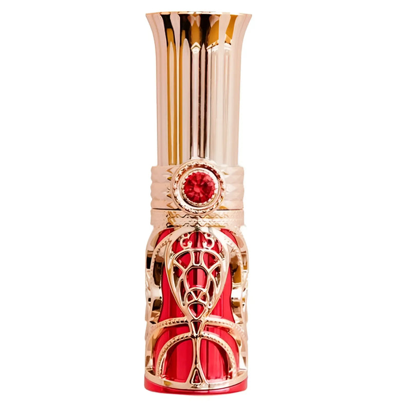 Ornamental gold and red cosmetic tube with a red gem, white background.
