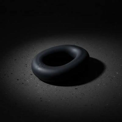Brutus Sex Toys cock ring showcased in a dramatic low-light setting, highlighting its sleek design and premium material.