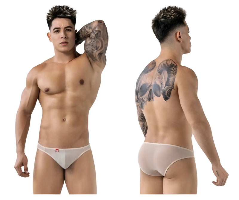 Tattooed man wearing sheer beige briefs against a plain white background studio.