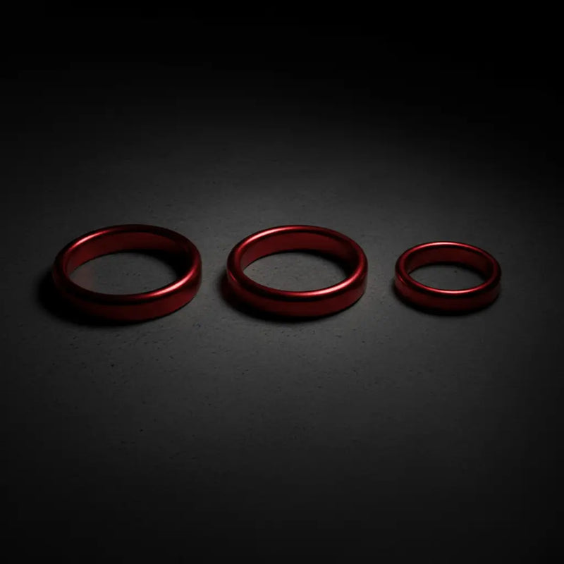 Three red metallic rings of varying sizes arranged in a row in the si novelties collection