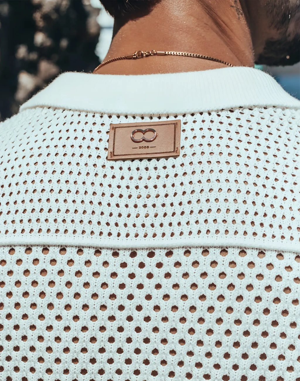 White perforated knit 2EROS amalfi shirt with tan leather patch featuring infinity symbol and year 2008
