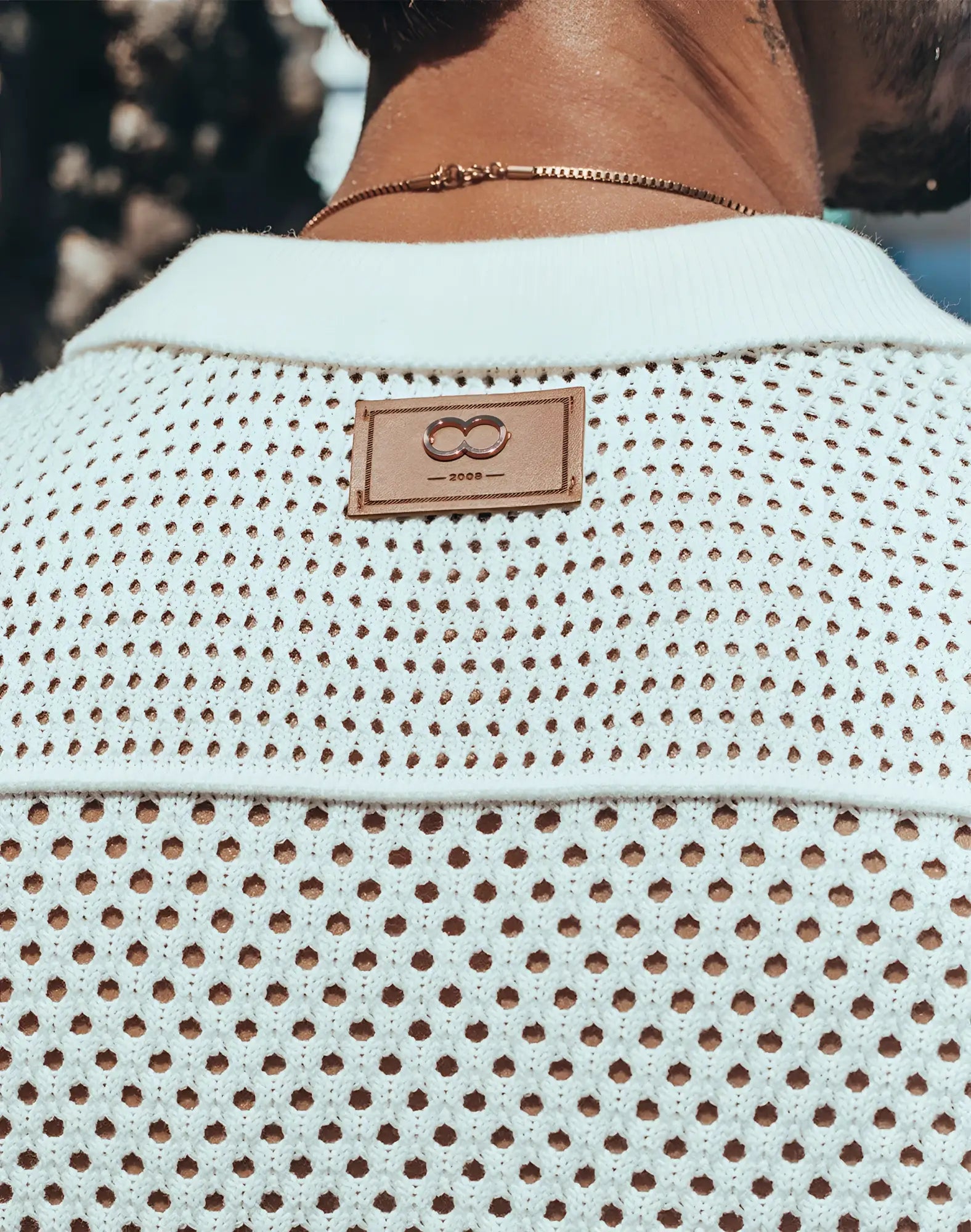 White perforated knit 2EROS amalfi shirt with tan leather patch featuring infinity symbol and year 2008