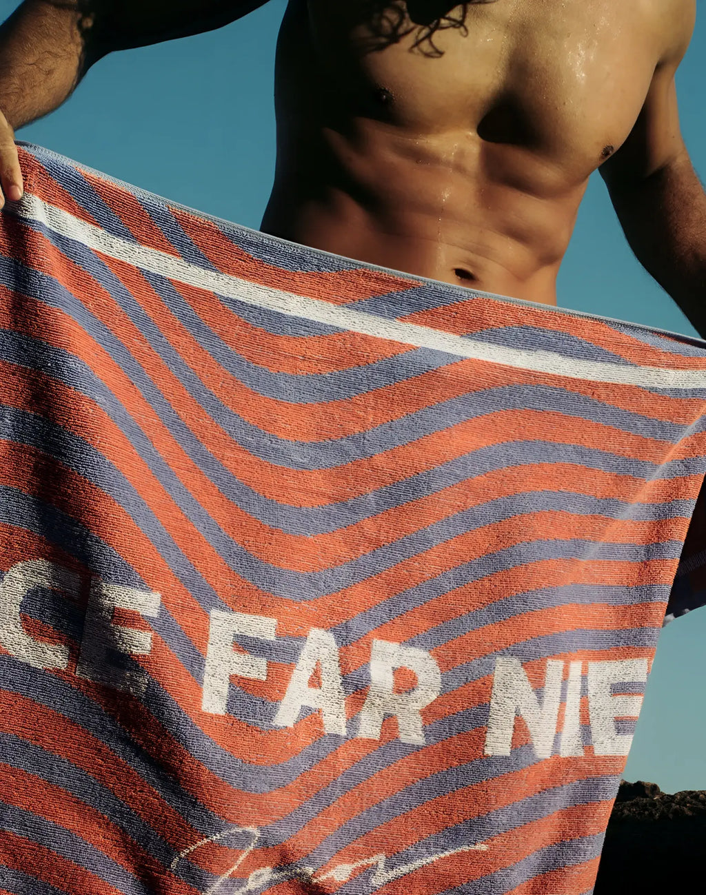 2eros beach towel in orange and blue wavy stripes with white ice far nie text ideal for beach use