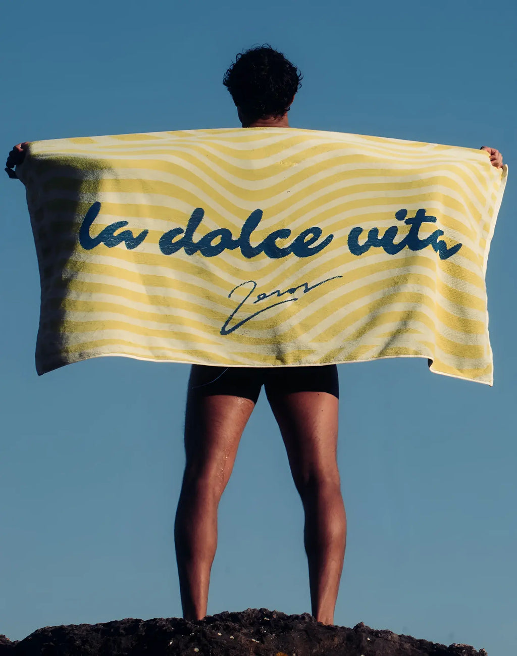 2EROS beach towel in yellow and white stripes with blue la dolce vita cursive print for beach use