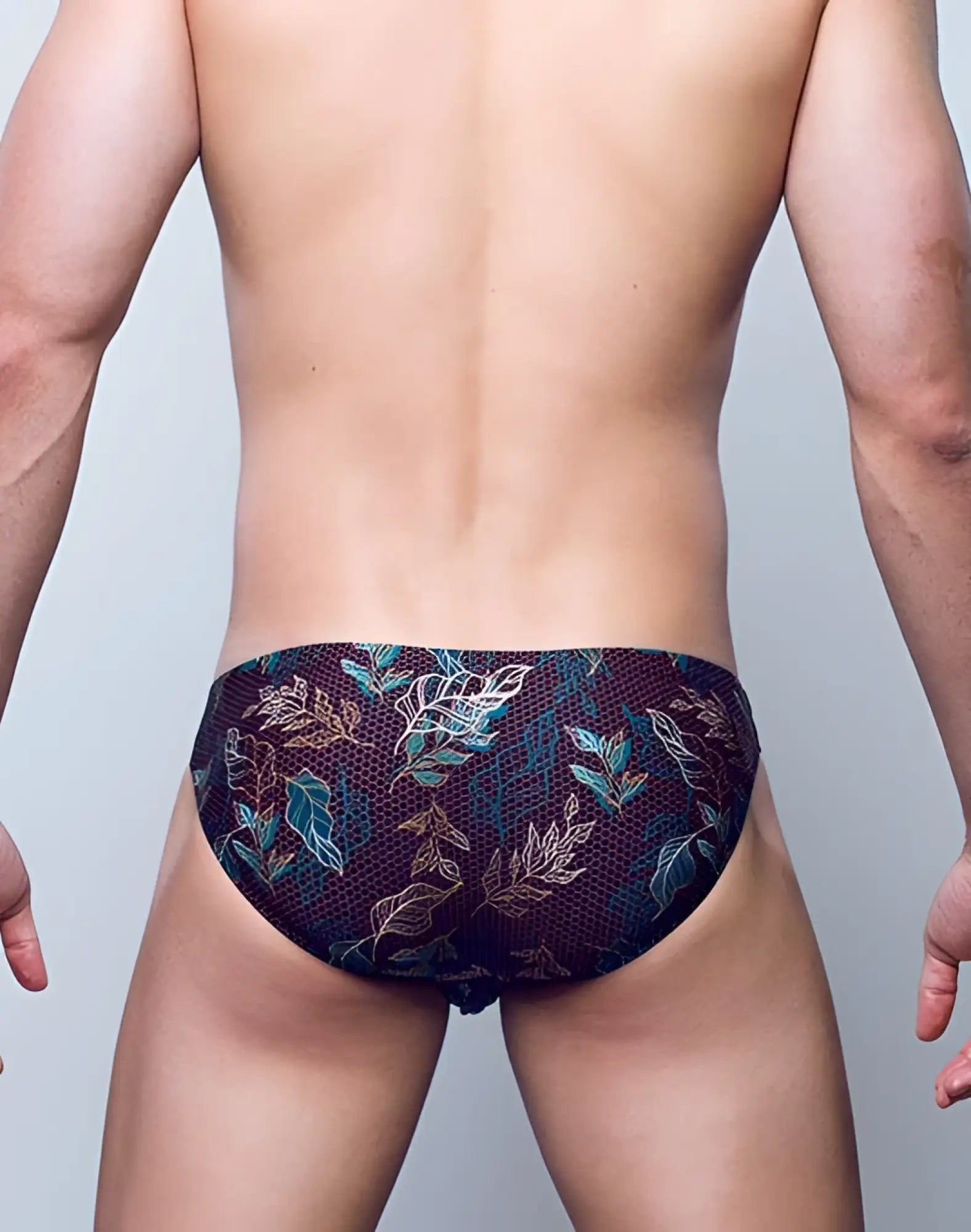 Dark navy 2EROS BLK Label No.2 swim brief with teal and gold leaf print and intricate mesh texture