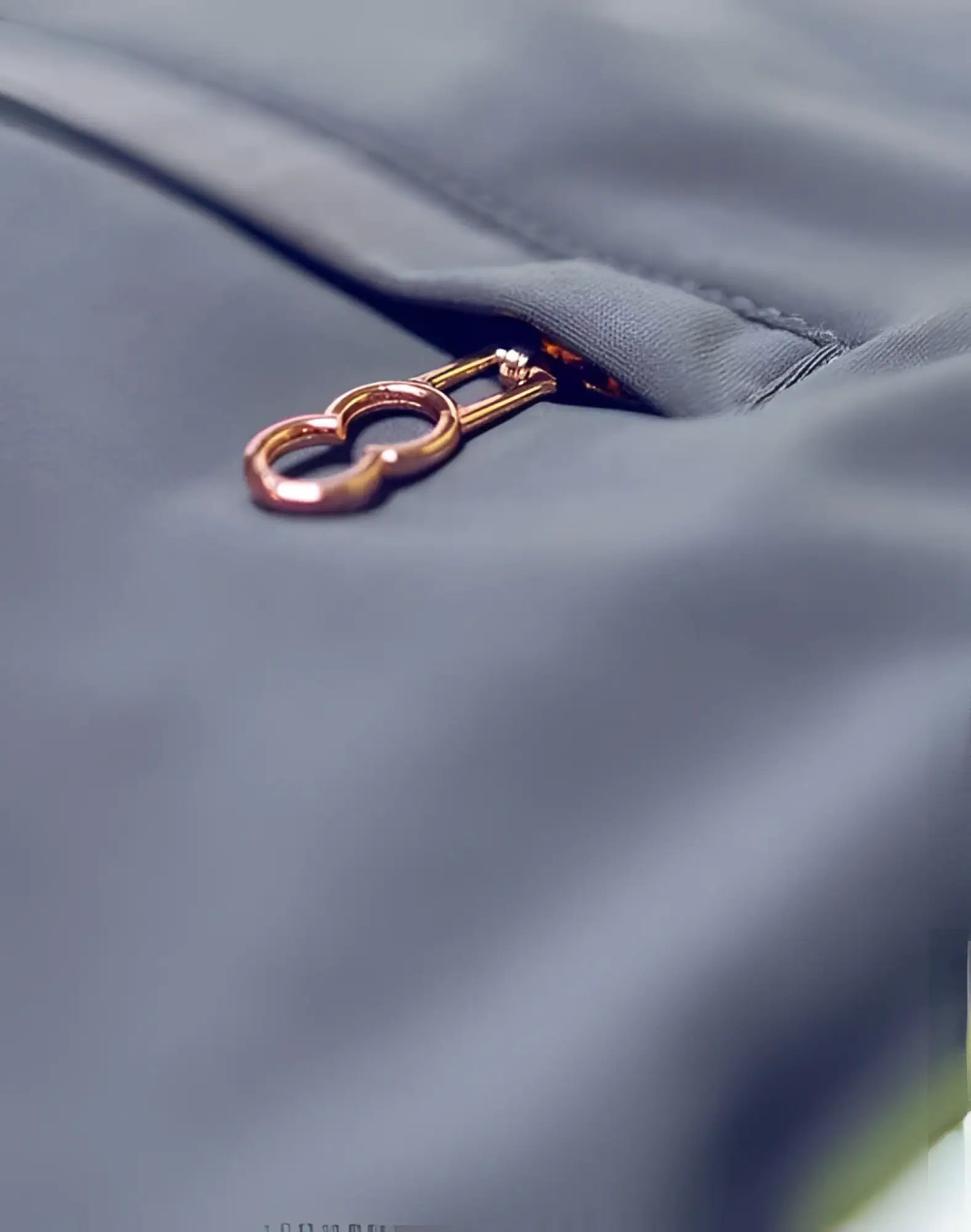 A rose gold heart-shaped zipper pull on dark gray alloy 2eros bondi shorts series 3 fabric