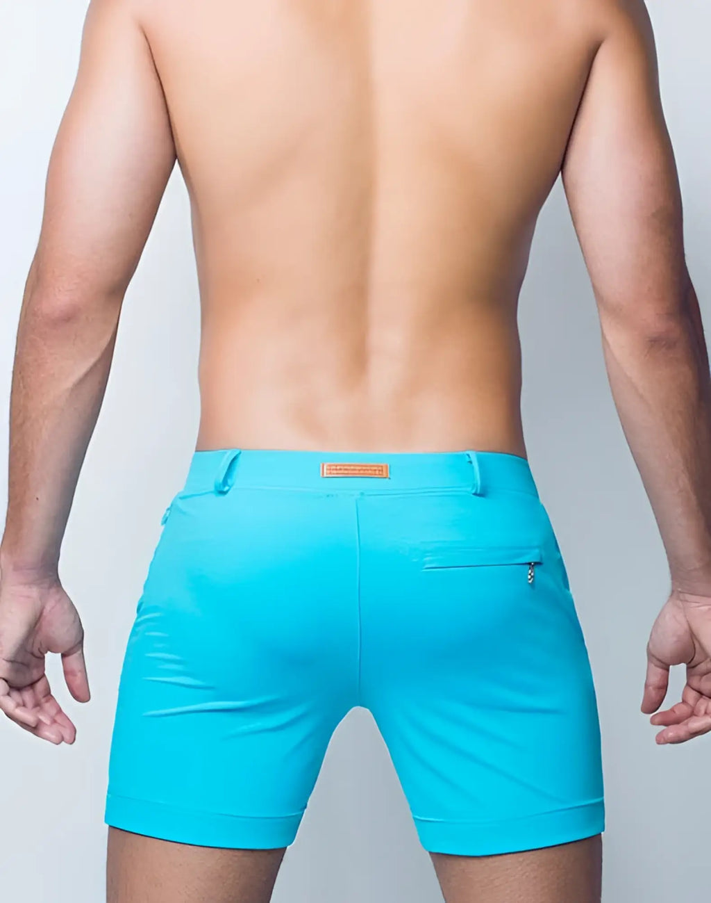 Bright turquoise 2EROS Bondi shorts with sleek modern design and small brown leather patch at the waistband