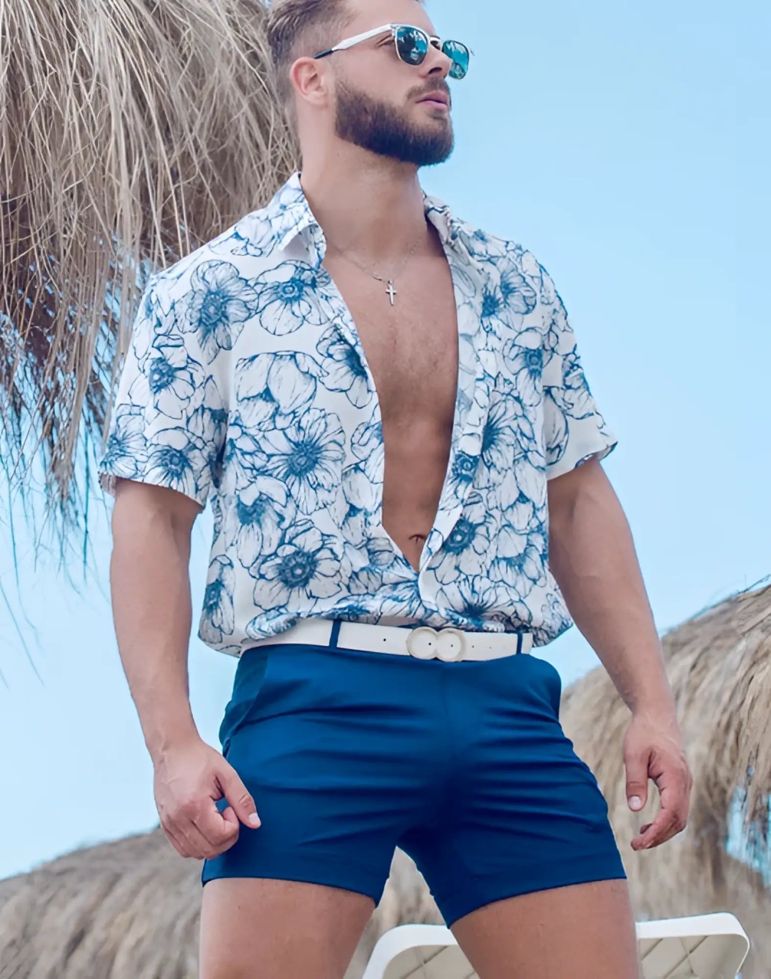 Man wearing 2eros bondi shorts series 3 navy made of lightweight fabric paired with white shirt with blue floral pattern