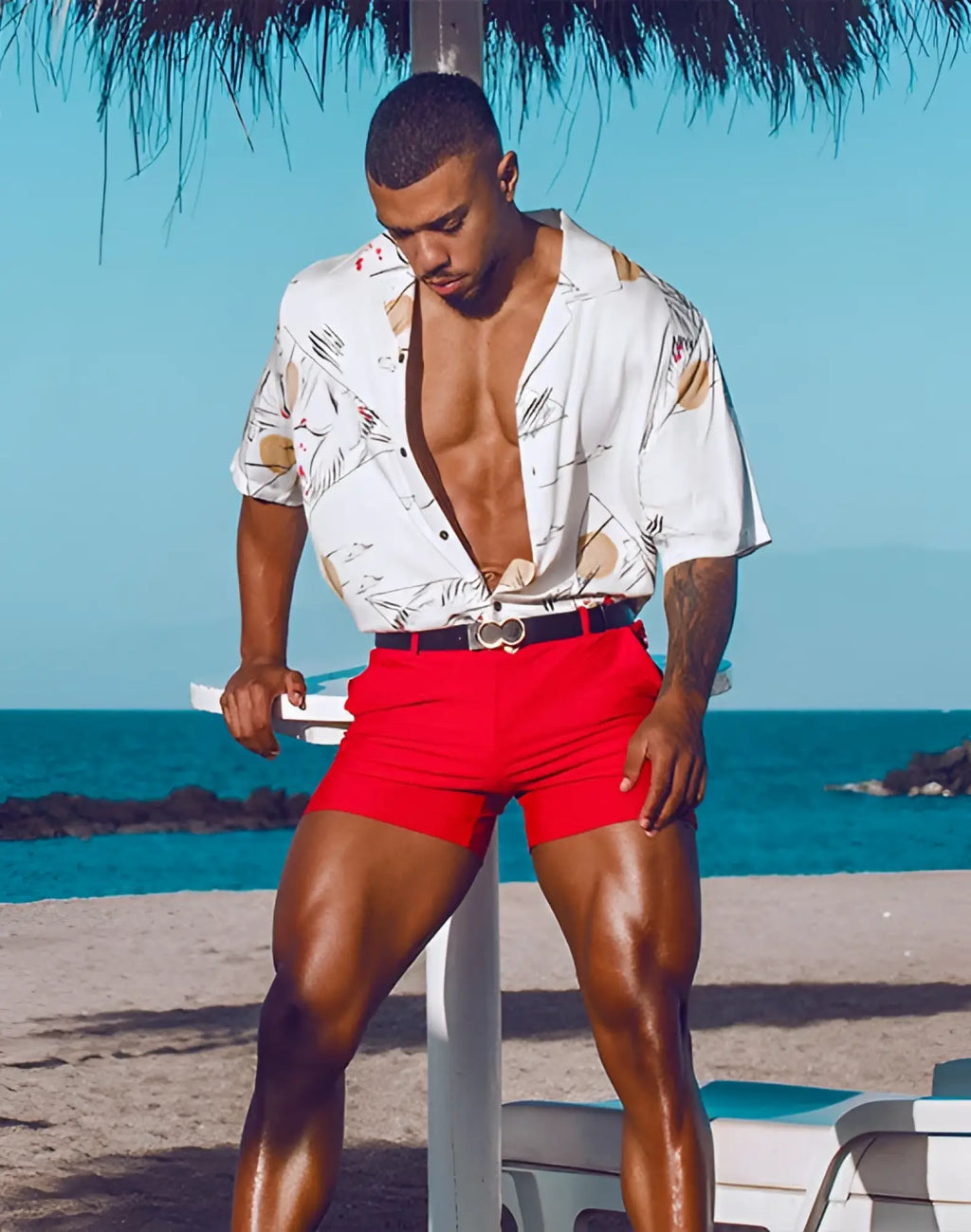 White short-sleeved button-up shirt with tropical leaf and beige floral pattern paired with 2EROS Bondi rust shorts