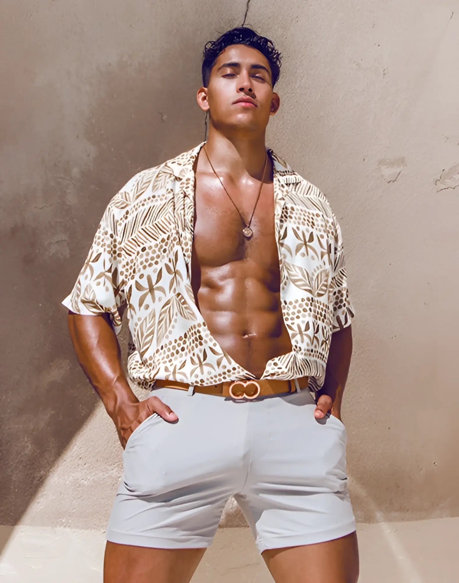 A tan and white patterned short-sleeved shirt with leaf and dot motifs paired with 2EROS bondi shorts string brown