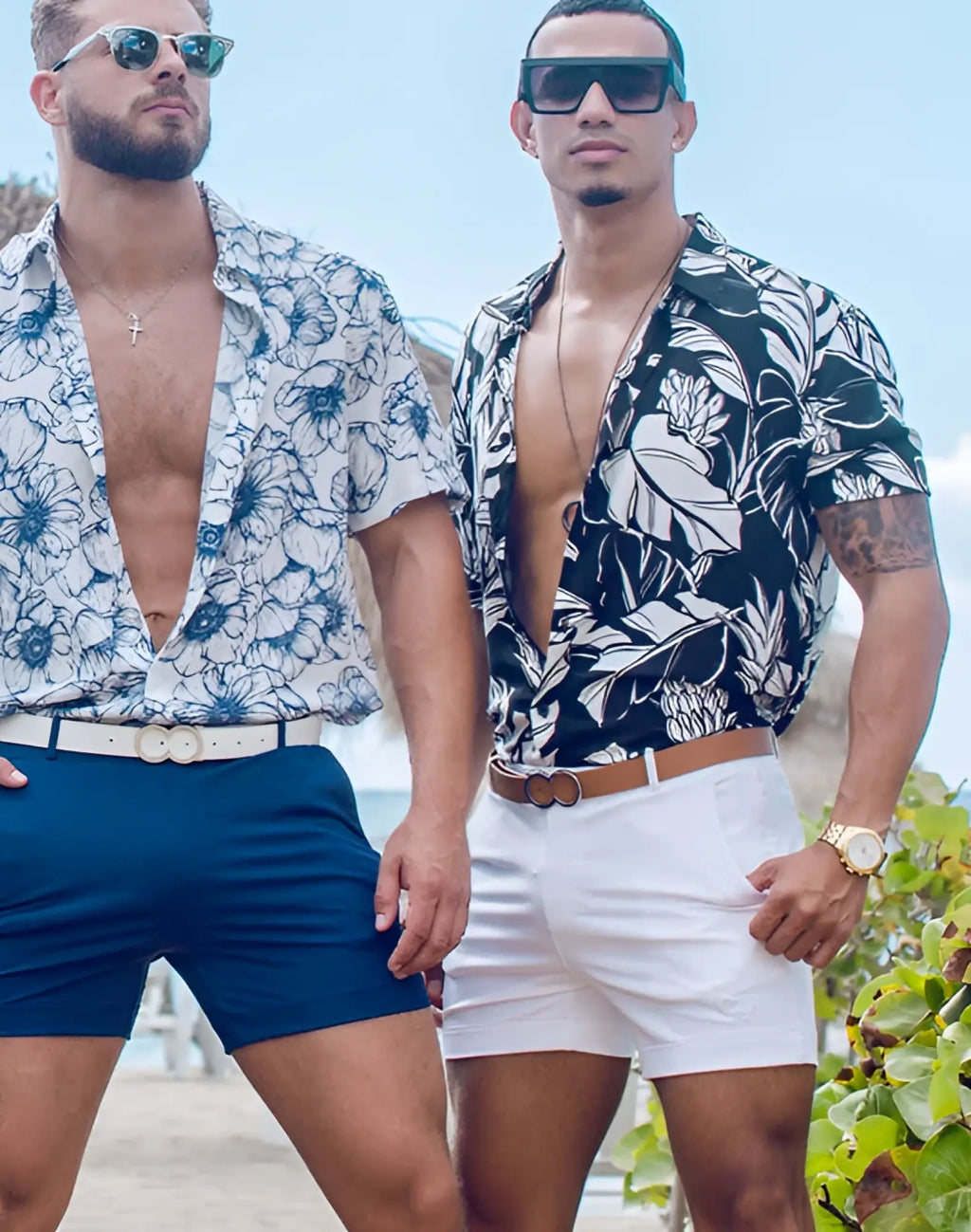 The man on the right wears black and white tropical leaf patterned short-sleeve shirt with 2eros bondi white shorts
