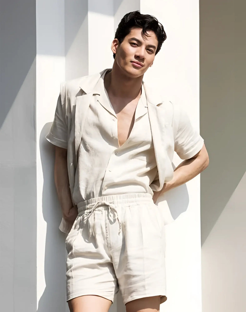 A man wearing 2EROS breezy 6 inch classic linen beige shorts with a light beige linen short-sleeved shirt and open collar