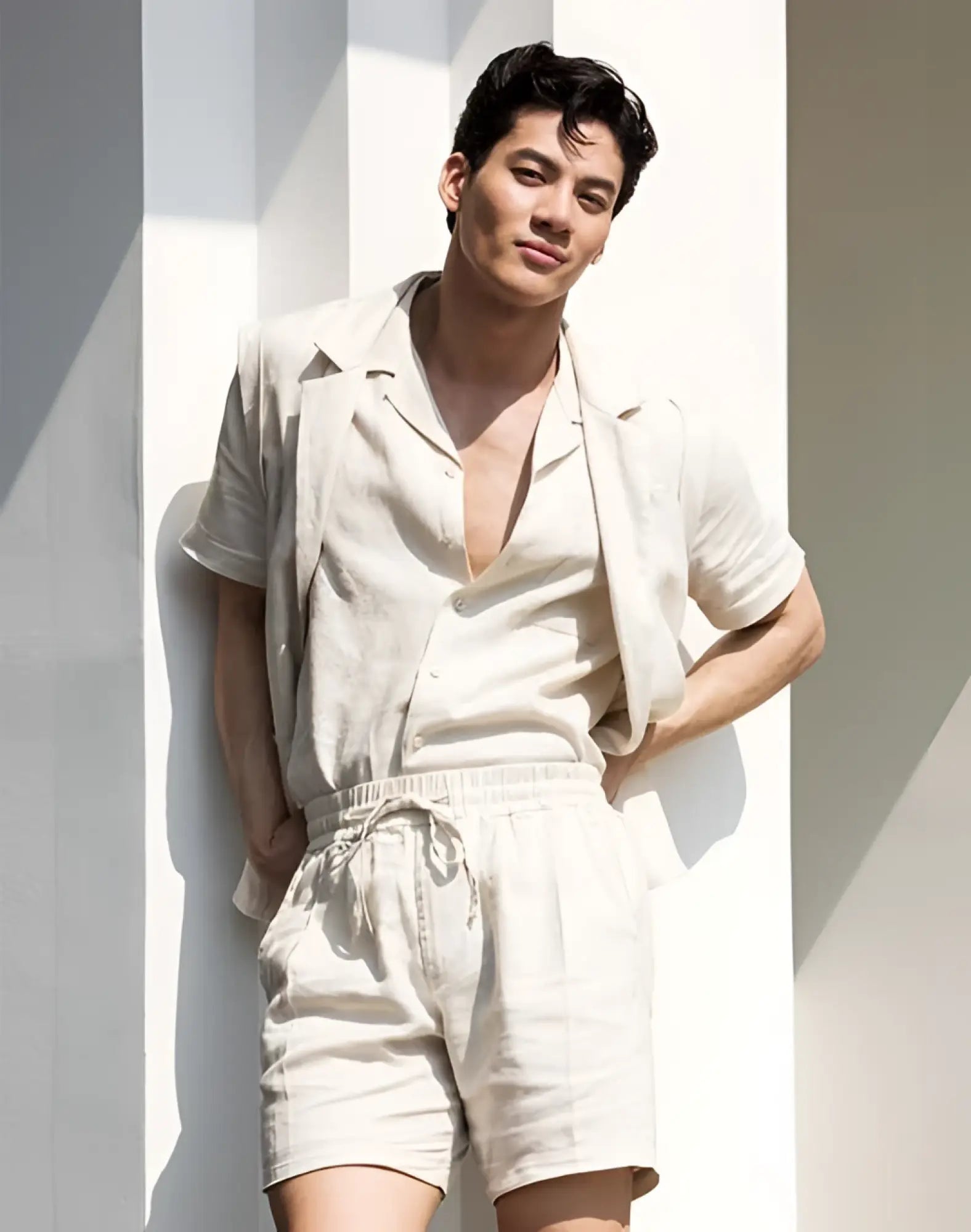 A man wearing 2EROS breezy 6 inch classic linen beige shorts with a light beige linen short-sleeved shirt and open collar