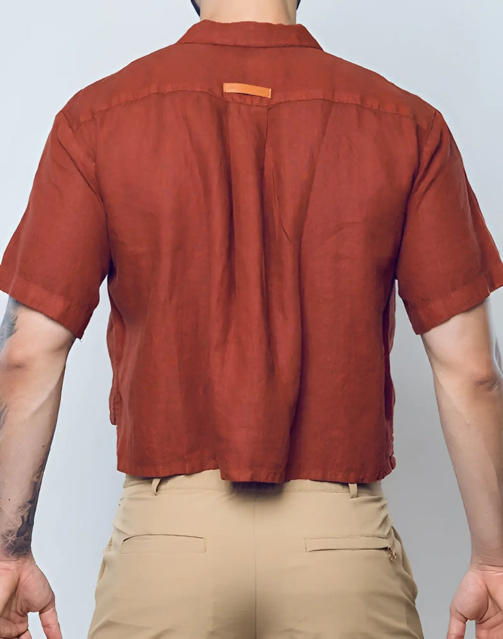 A rust-colored cropped short-sleeved 2EROS linen shirt with collar and subtle stitching details in Bombay Brown