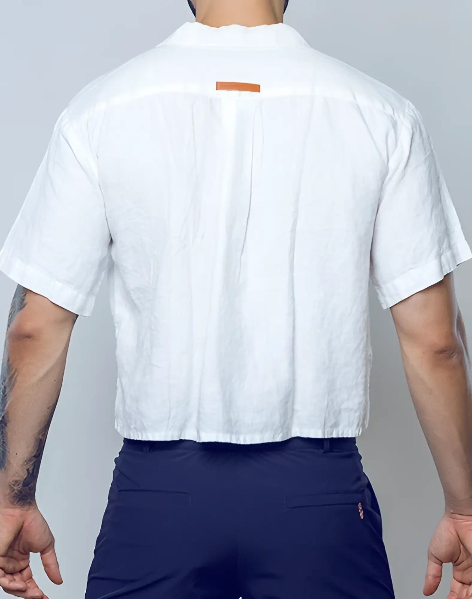 2EROS cropped white linen short-sleeved shirt with subtle texture and orange rectangular tag at neckline