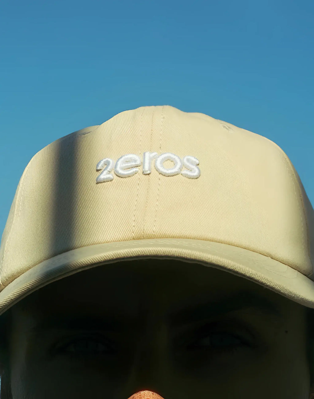 Beige 2EROS icon cap featuring a white embroidered 2eros logo in a classic baseball cap style
