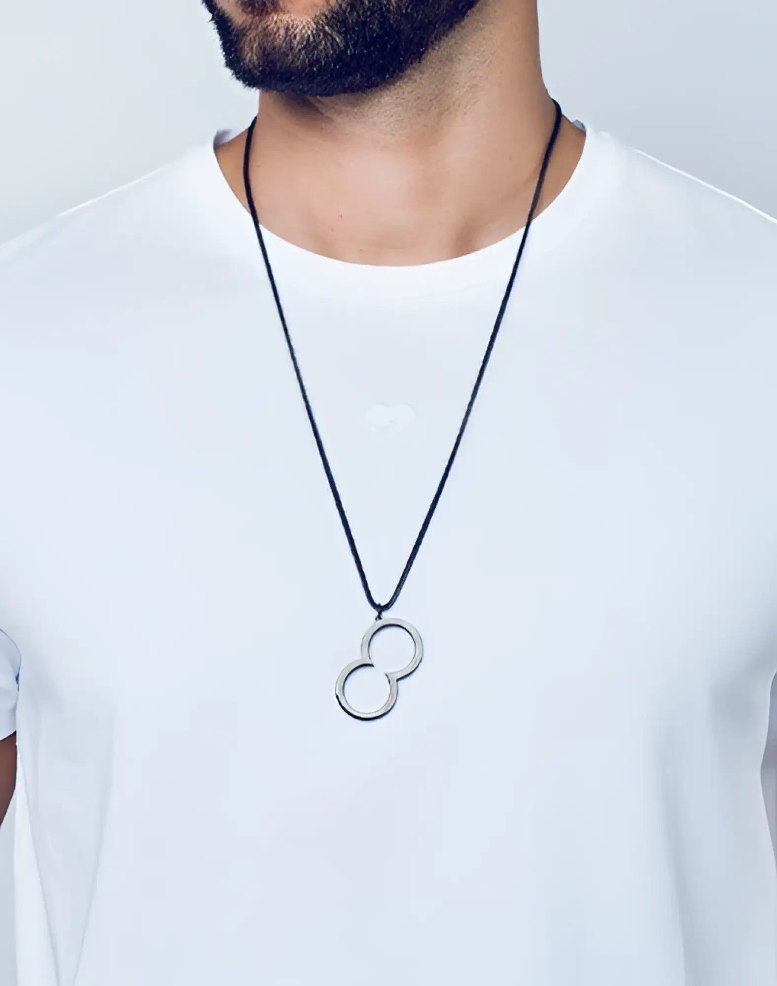 Silver infinity symbol pendant on a black cord necklace.