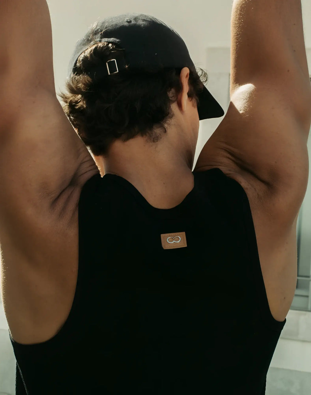 Back view of 2EROS icon singlet black sleeveless athletic tank top with small brown logo patch on the back