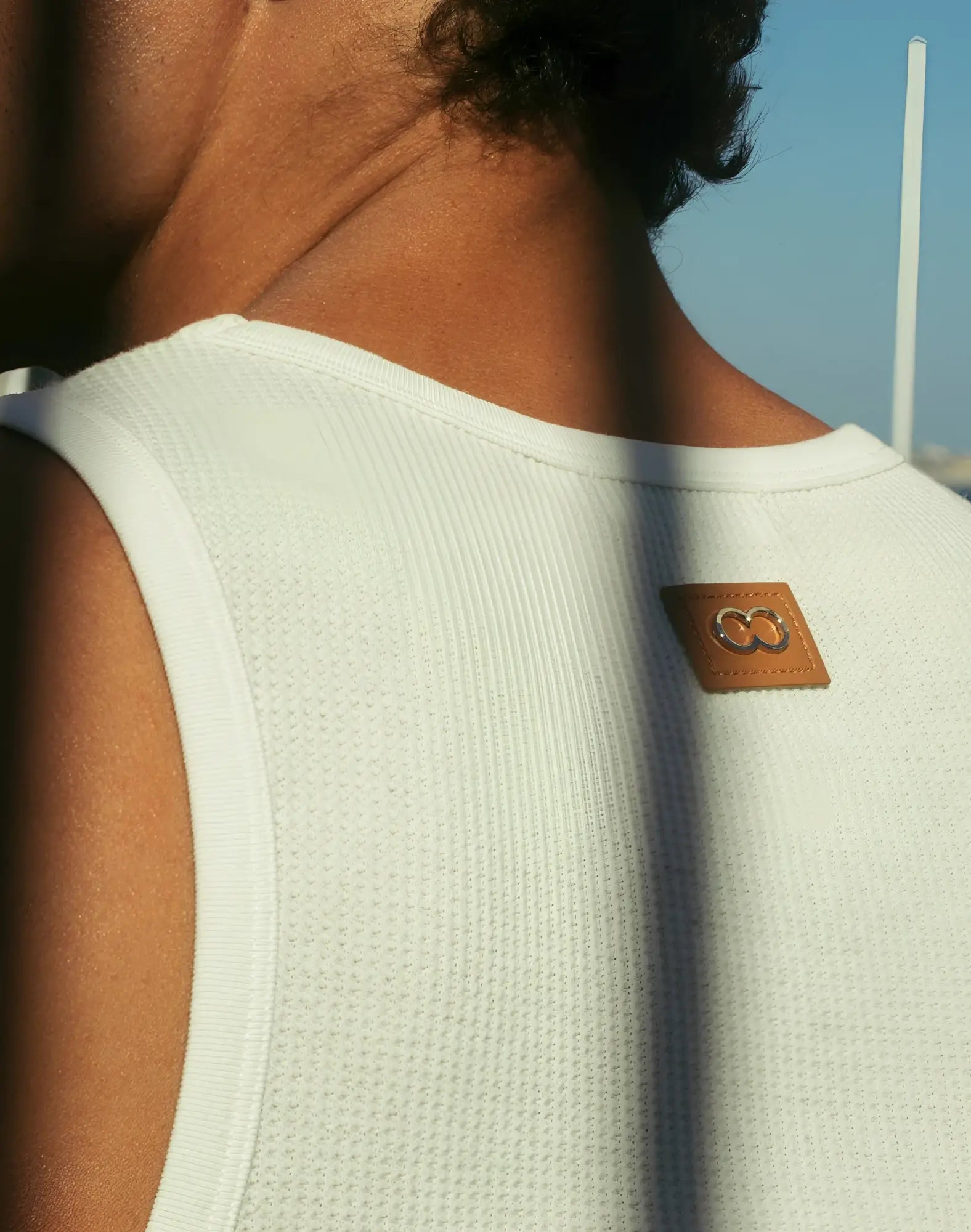 Back view of 2eros icon singlet white ribbed tank top with tan leather patch and embroidered logo