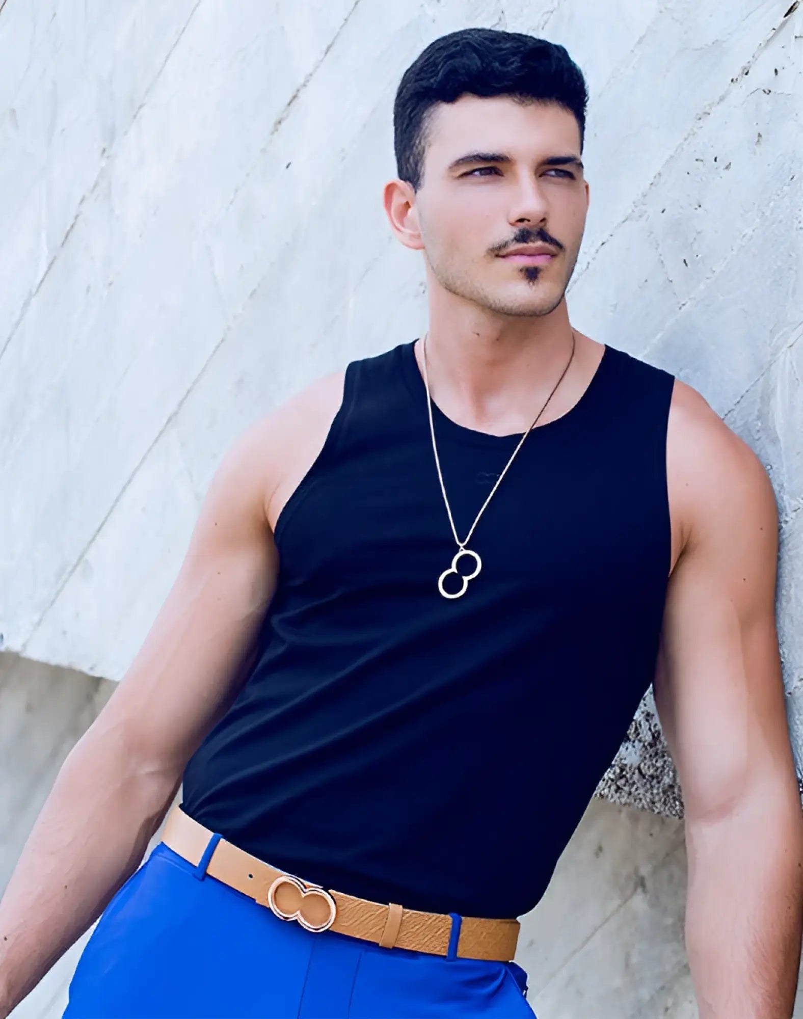 2eros logo pendant necklace in rose gold featuring a gold infinity symbol with thin chain and matching double-ring belt buckle