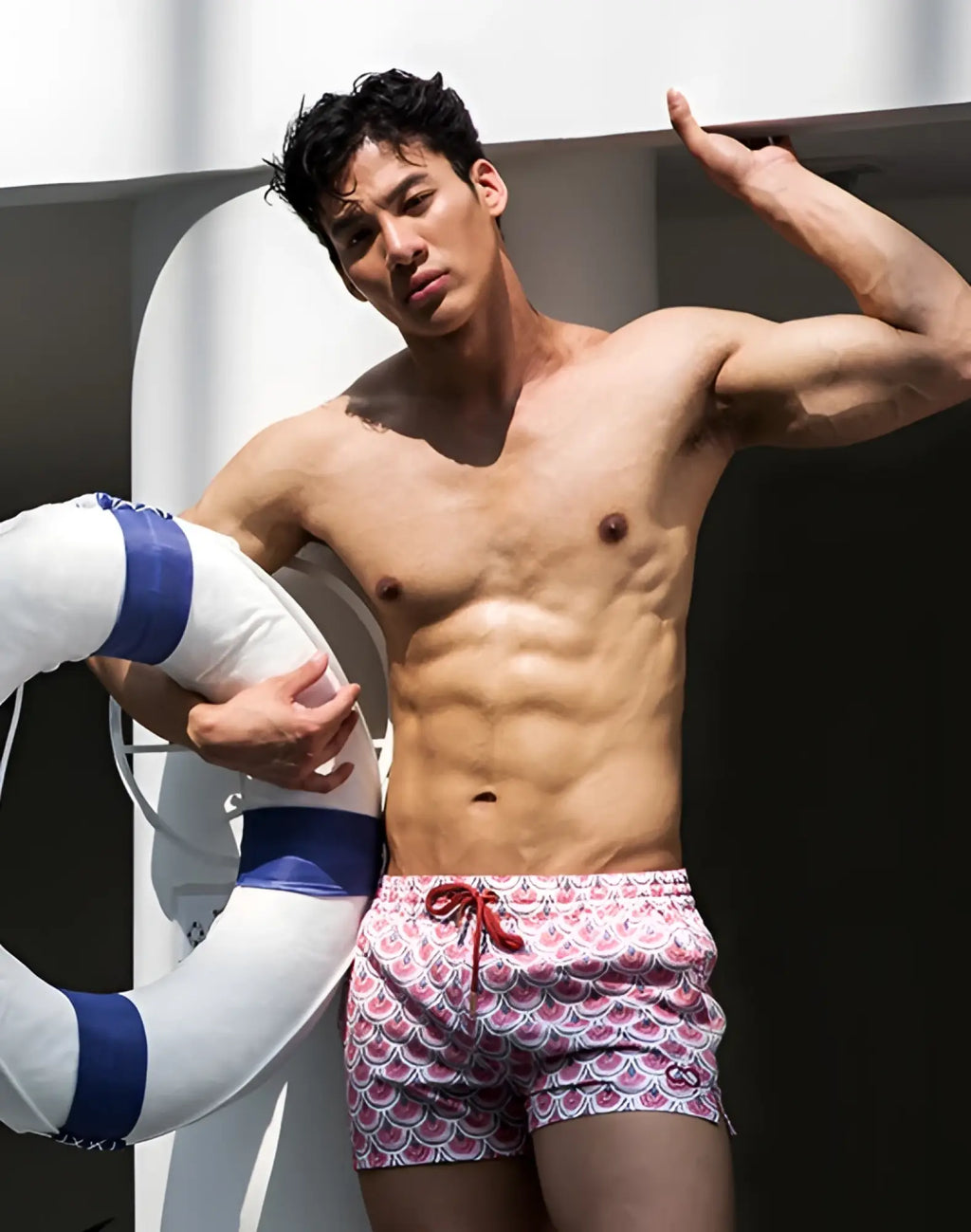 A pair of 2eros printed bronte shorts men’s swim trunks with a vibrant pink and white scalloped pattern and red drawstrings