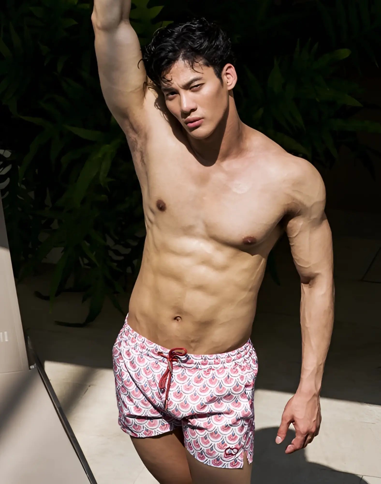 A pair of 2eros printed bronte shorts with white base pink scalloped wave patterns and red drawstrings for men