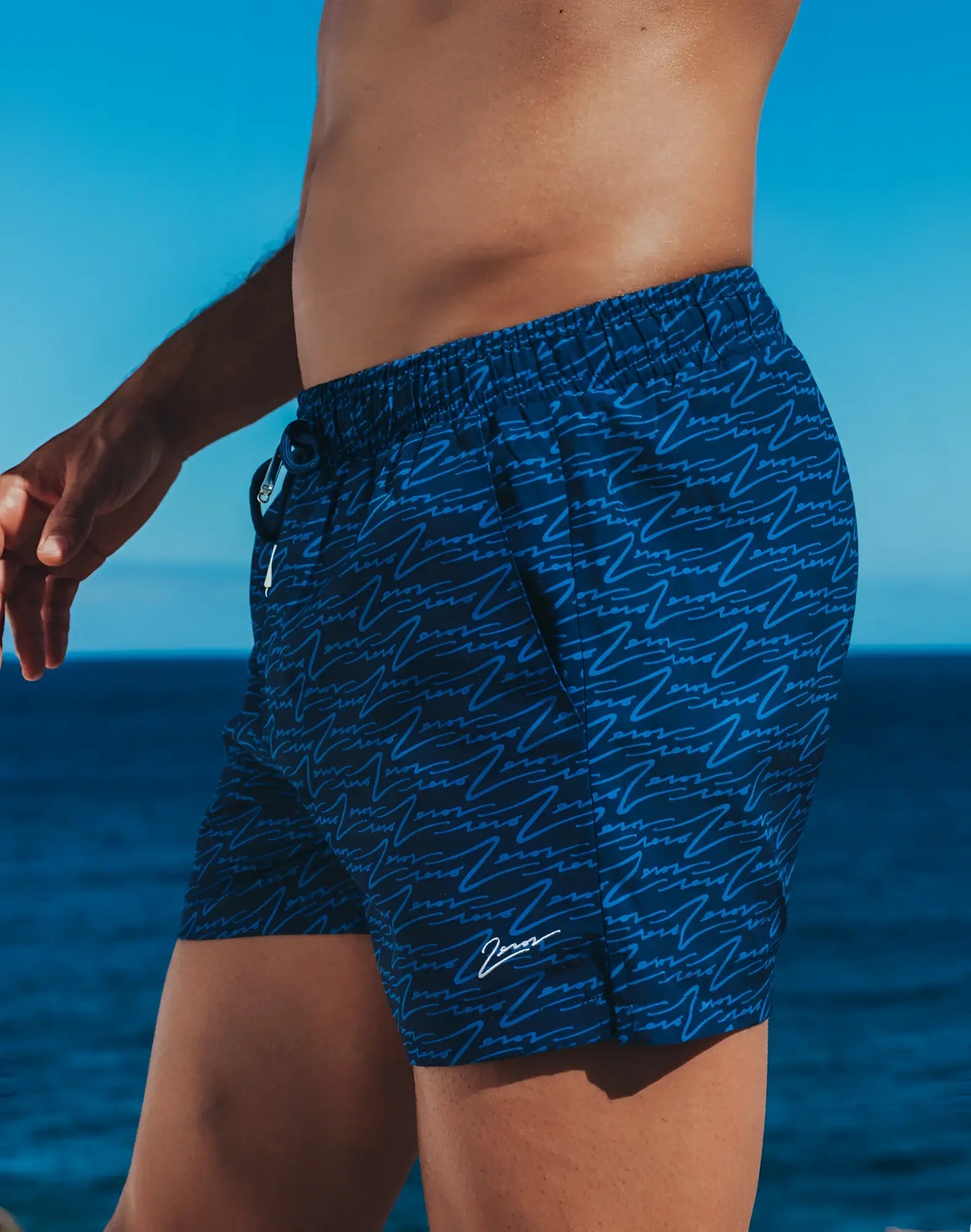 Dark blue 2EROS printed Bronte shorts with light blue abstract wave pattern and white signature logo on lower right leg