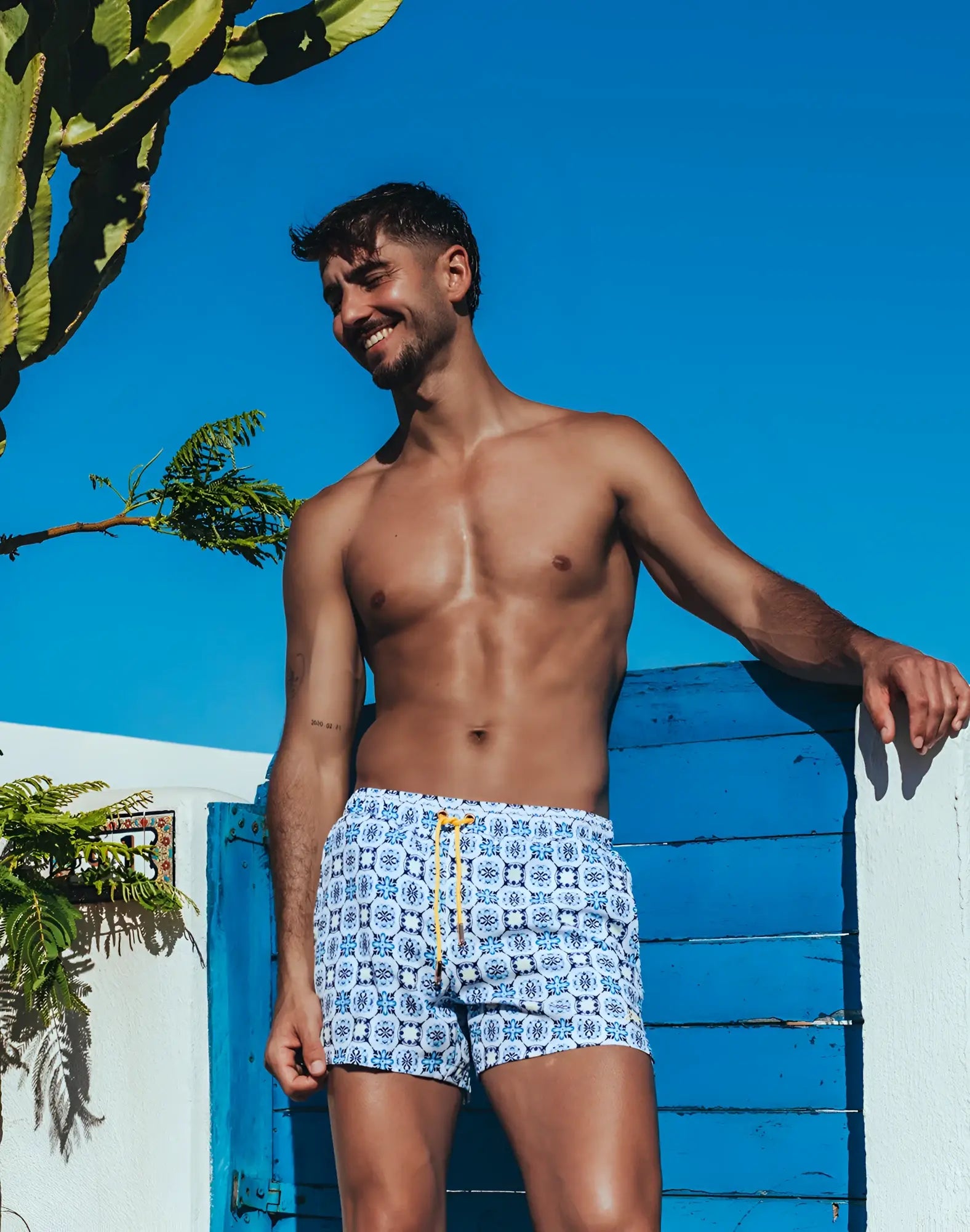 White 2EROS printed Byron shorts with blue geometric pattern and yellow drawstring swim trunks for Mykonos beachwear