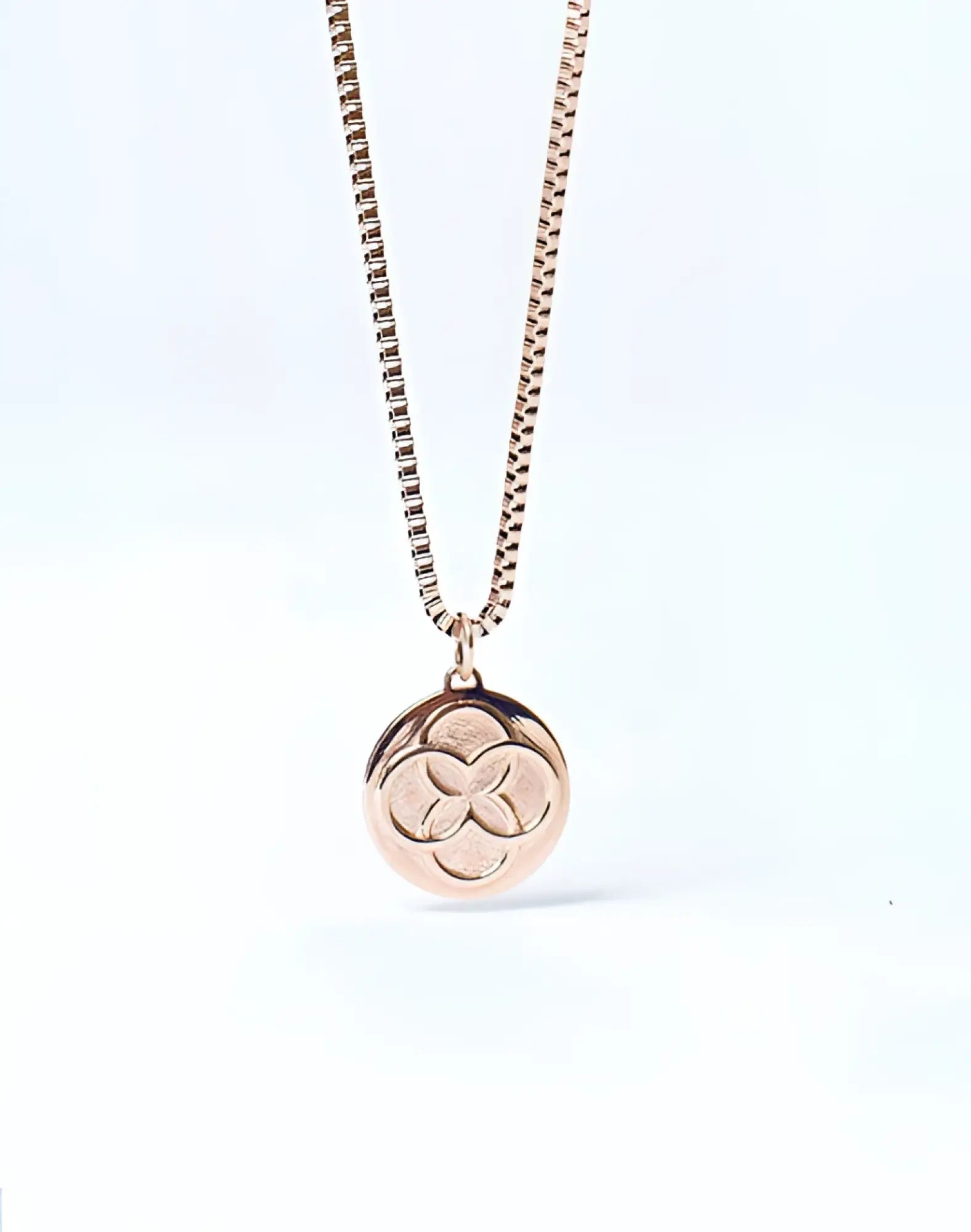 Rose gold 2EROS Regalia pendant necklace with a circular three-leaf clover design on the front