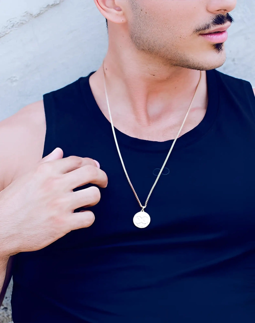 A 2EROS Regalia pendant necklace in rose gold with a sleek circular pendant featuring an engraved four-leaf clover