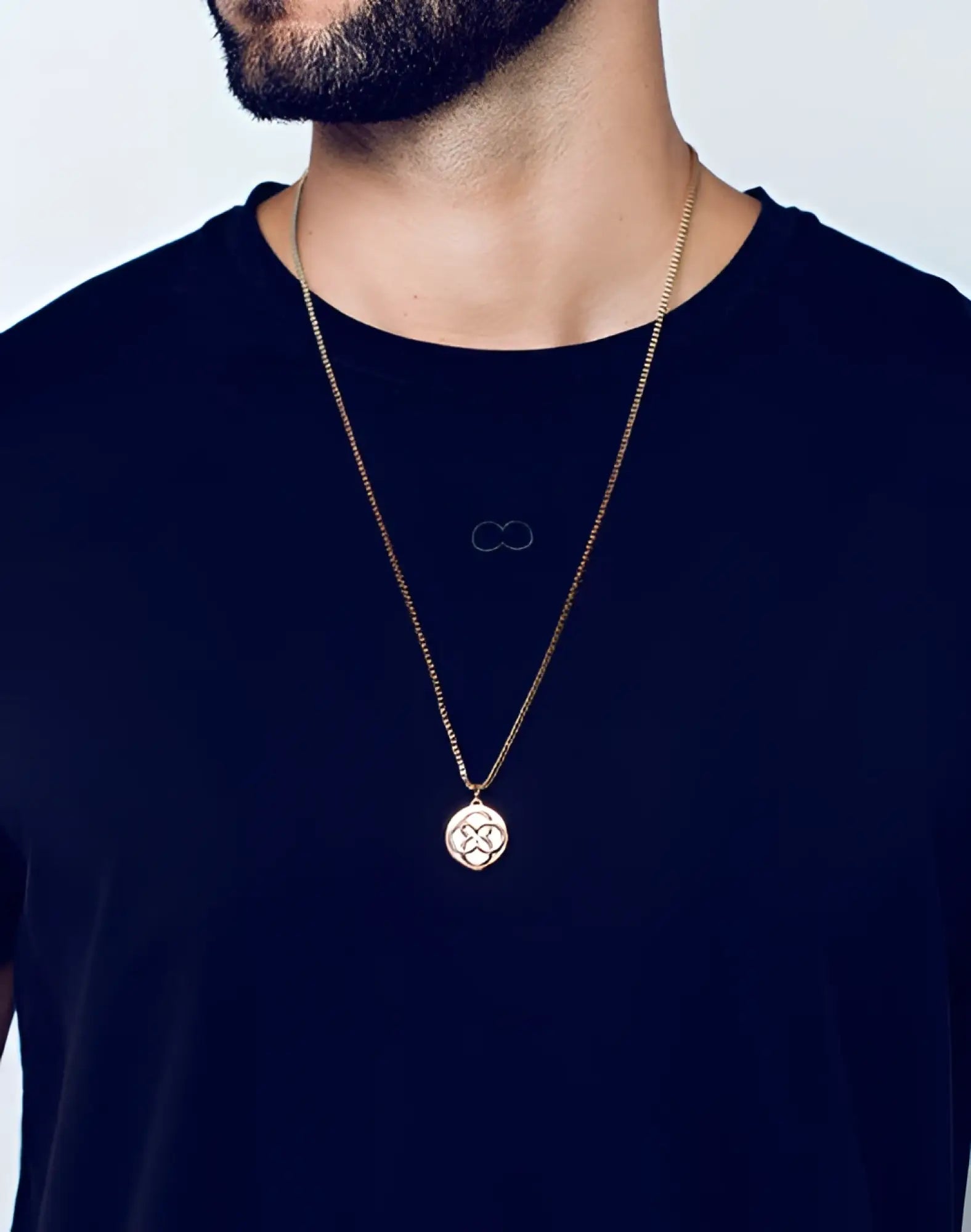 Gold-toned 2EROS Regalia pendant necklace with circular rose gold pendant featuring intricate geometric design