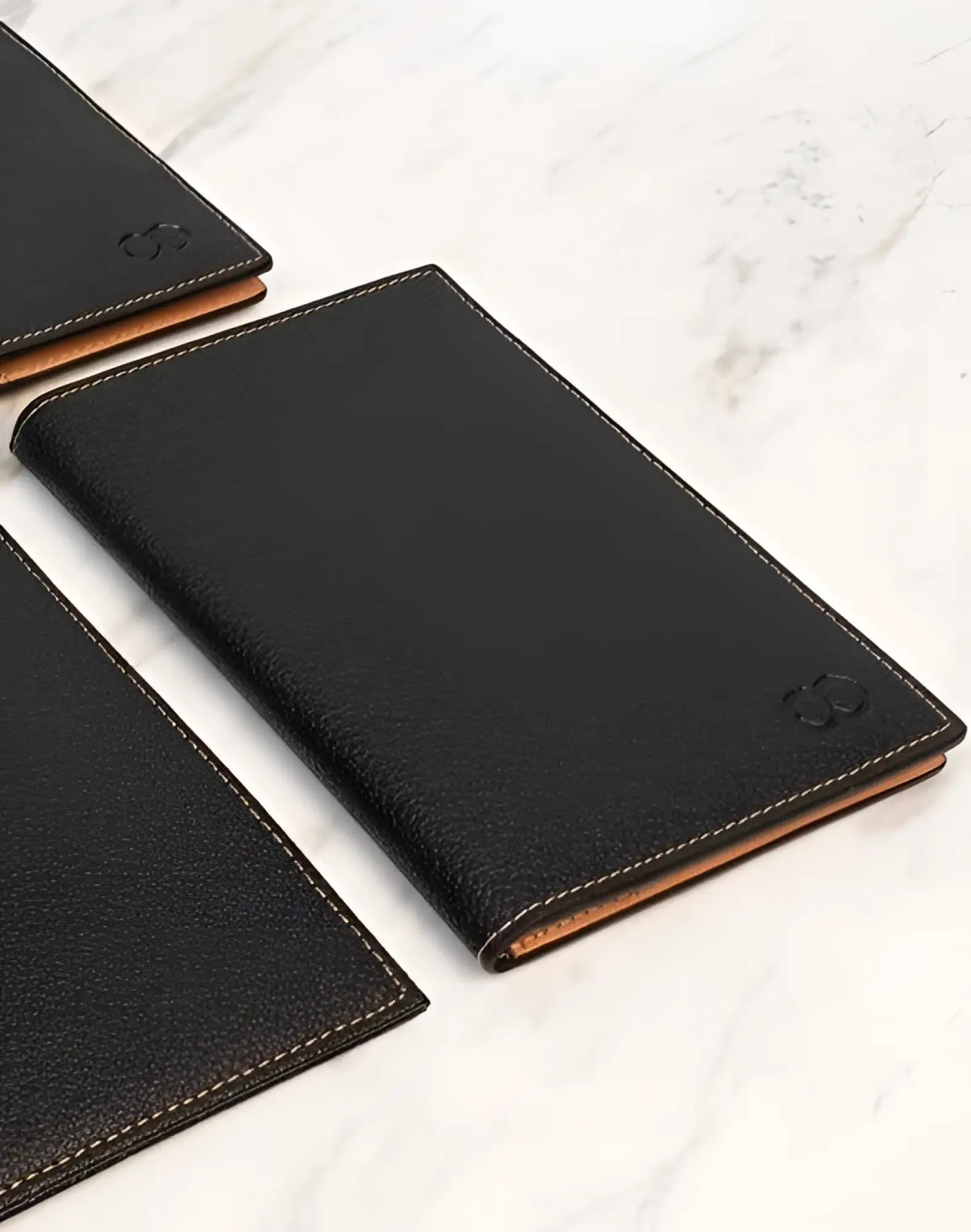 Black leather 2EROS RFID icon passport wallet with tan stitching and subtle embossed logo for secure travel