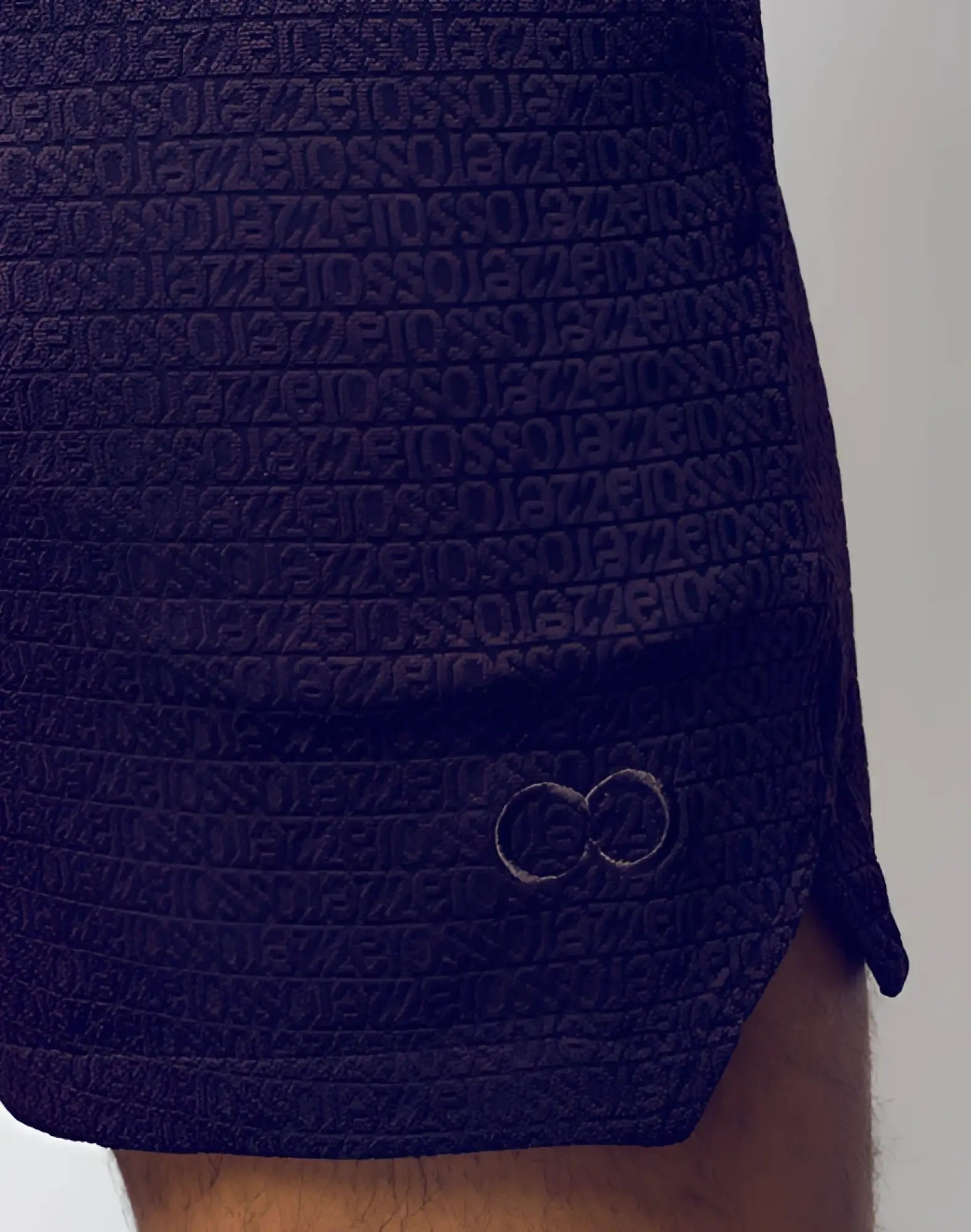 Dark purple 2eros s90 textured manly shorts with repeating letter pattern and subtle embroidered logo on the side