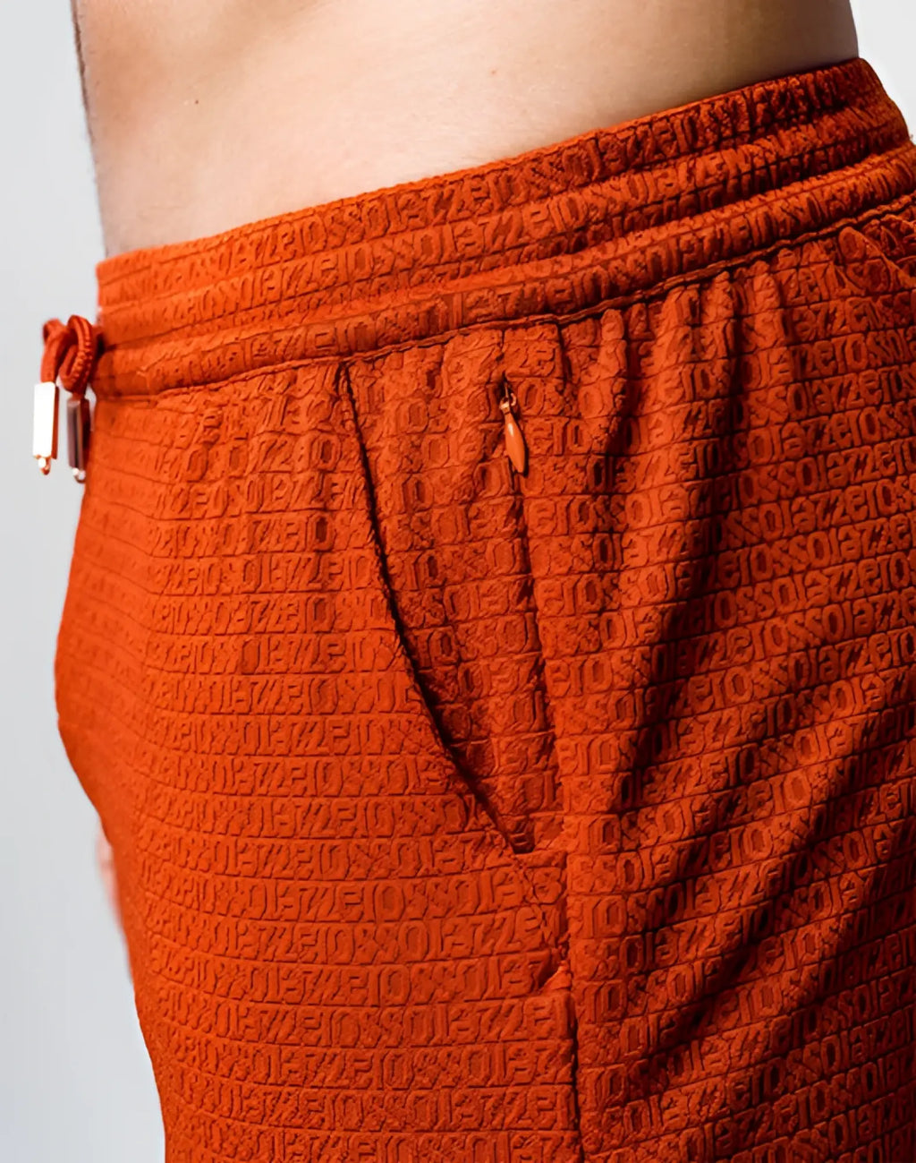 Orange textured joggers by 2EROS with embossed letters and numbers and elastic waistband with drawstrings