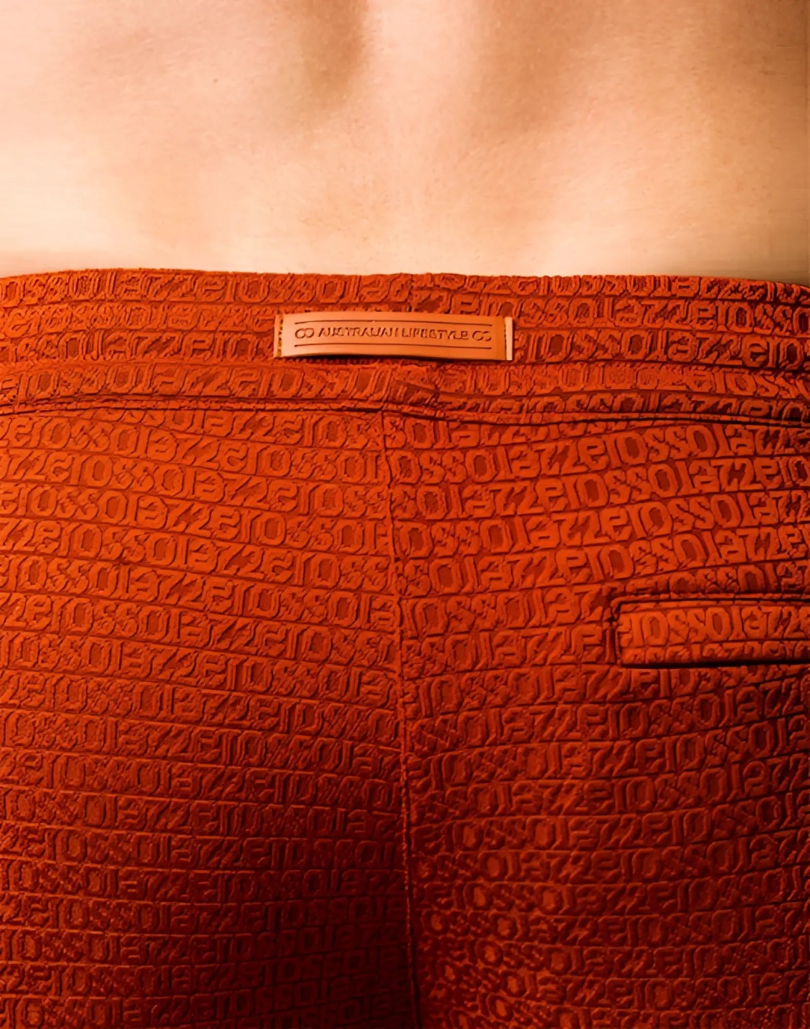 Orange 2EROS S90 textured manly shorts with embossed letters and numbers pattern and a small leather brand tag