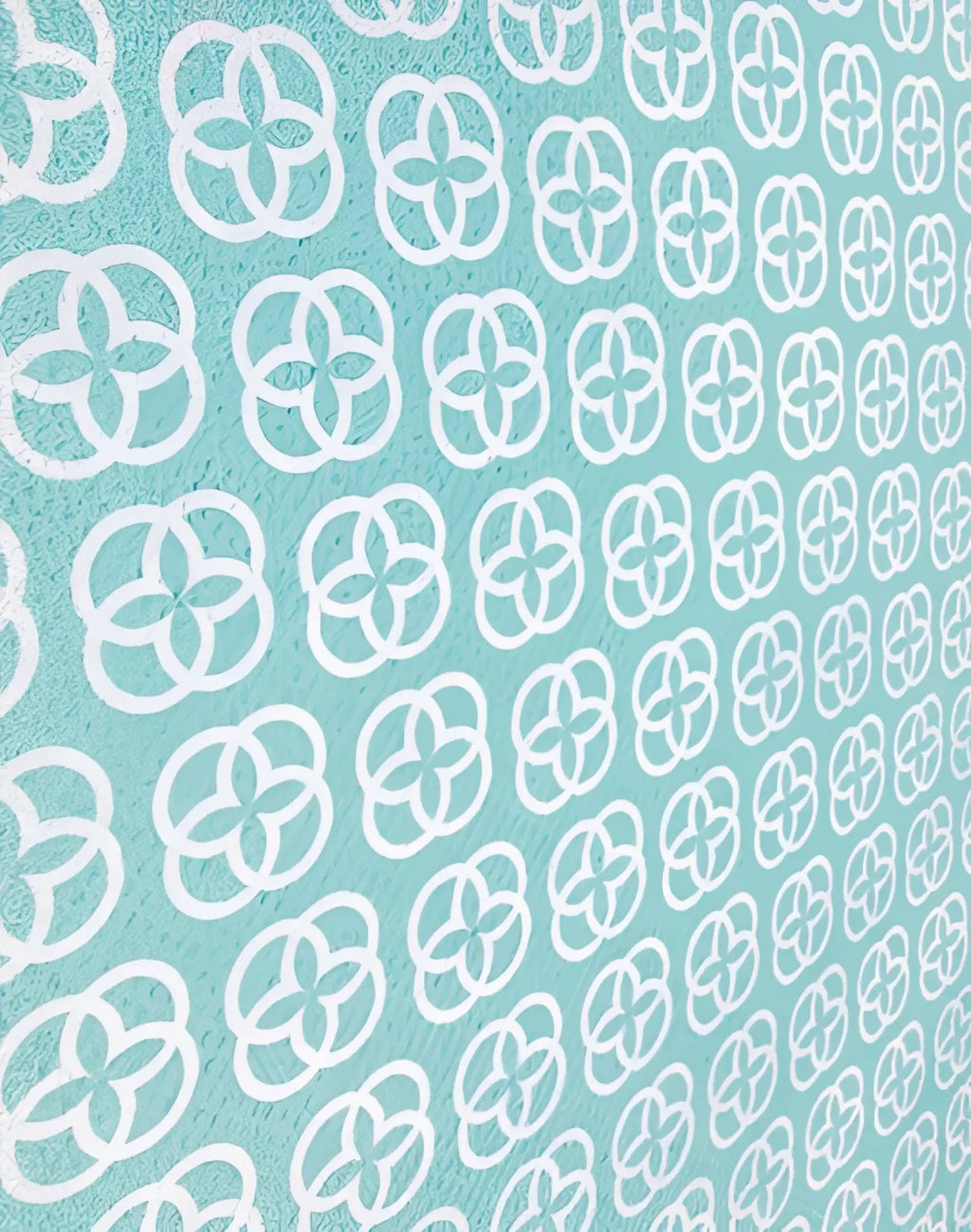A soft mint green 2eros sand-free beach towel with white quatrefoil pattern designed for beach use