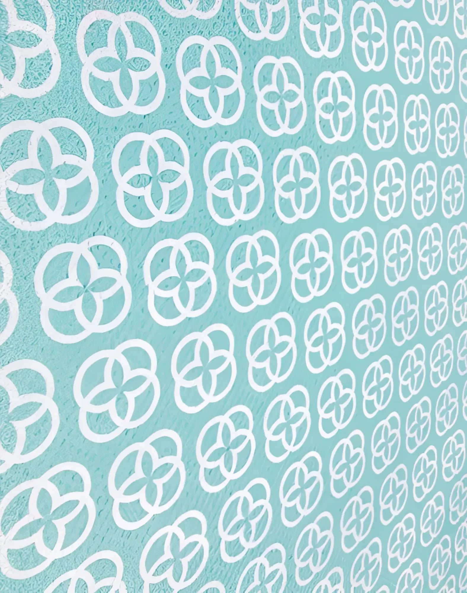 A soft mint green 2eros sand-free beach towel with white quatrefoil pattern designed for beach use