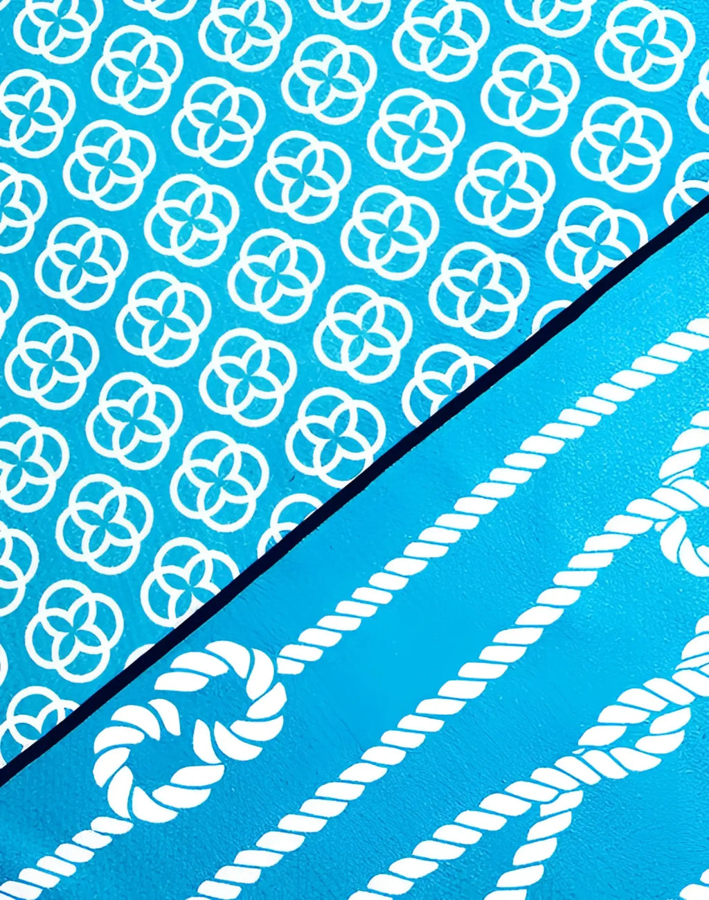 A vibrant turquoise 2EROS sand-free beach towel with bold white interlocking circles and rope motifs design