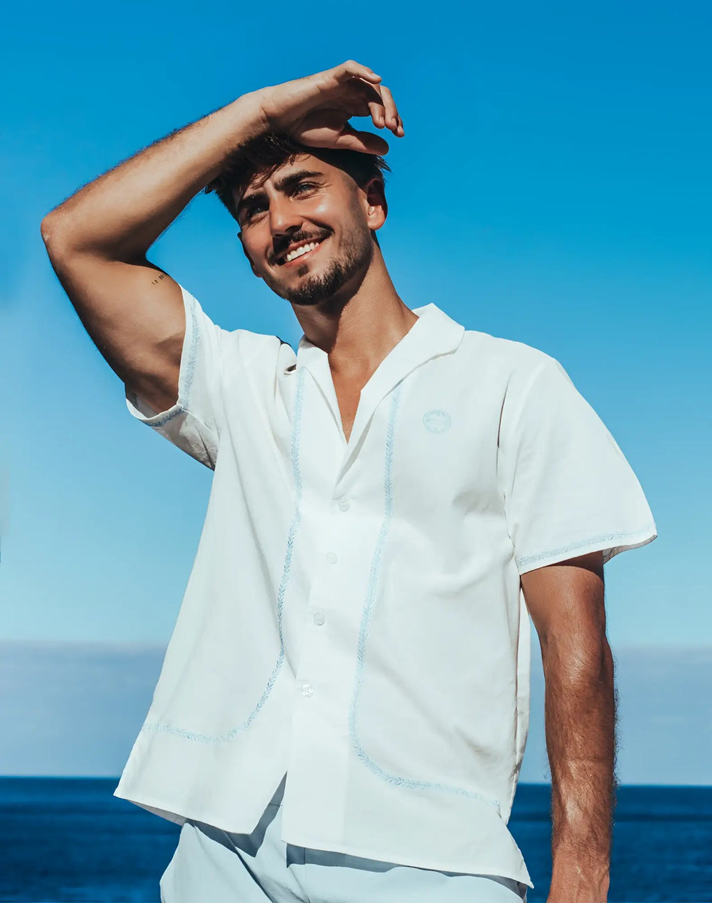 A crisp white 2EROS Santorini short-sleeved button-up shirt with subtle navy stitching and embroidered logo