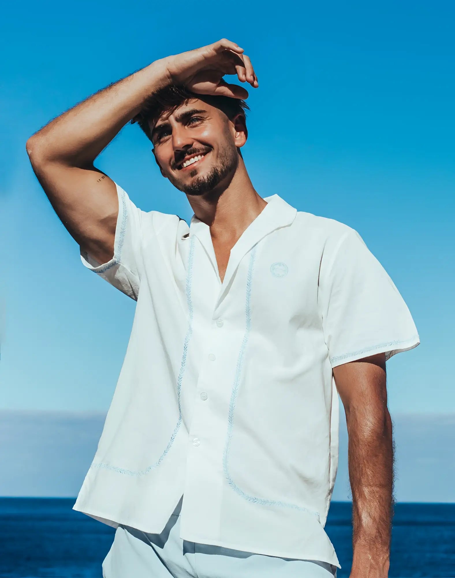 A crisp white 2EROS Santorini short-sleeved button-up shirt with subtle navy stitching and embroidered logo