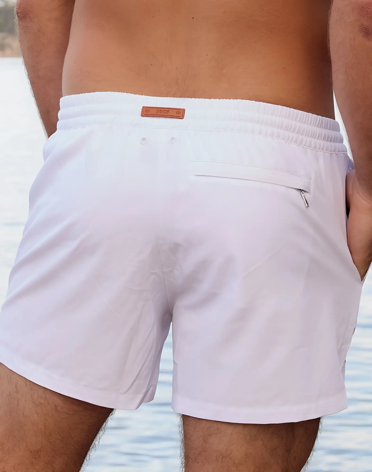 Back view of 2eros signature byron shorts white swim trunks with brown leather brand tag and small zippered pocket