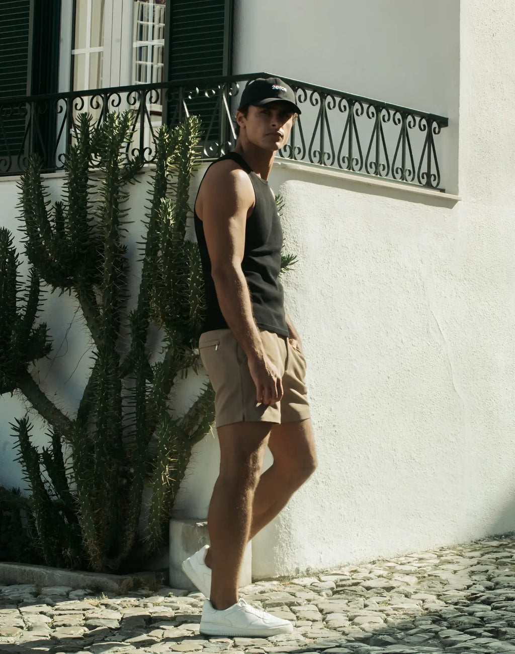 Black baseball cap with subtle logo on front paired with 2EROS trinity shorts in taupe for casual wear