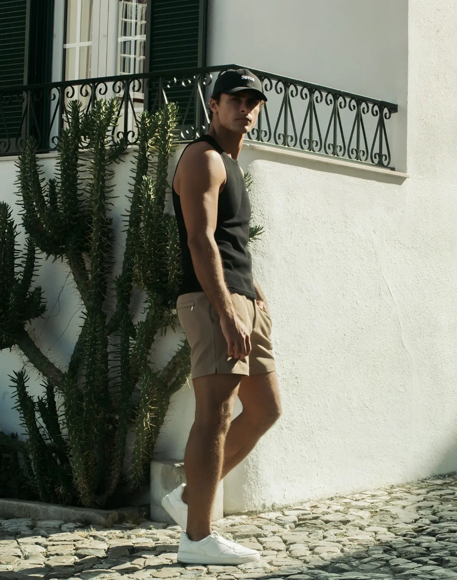 Black baseball cap with subtle logo on front paired with 2EROS trinity shorts in taupe for casual wear